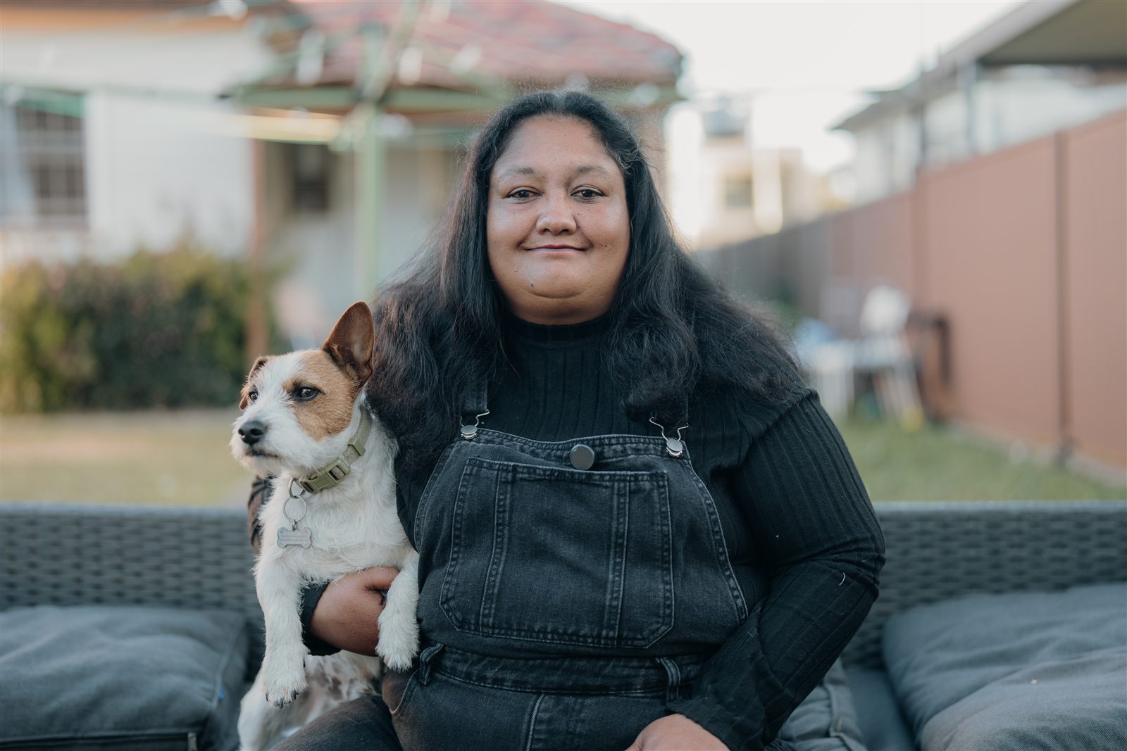 A woman relaxing in her backyard with her dog