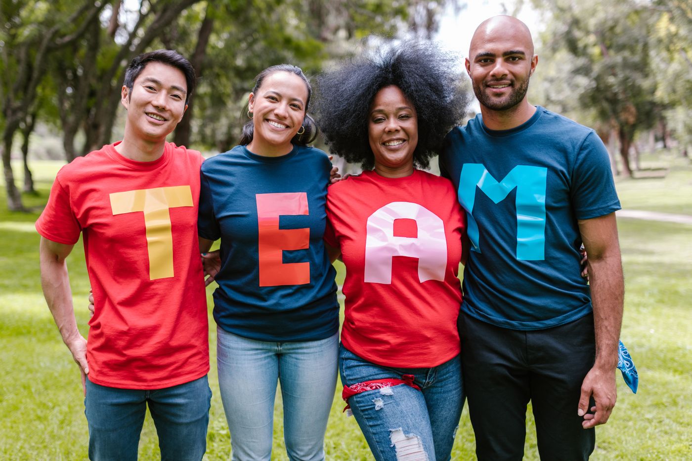 A diverse group of team members wearing TEAM t-shirts in a park